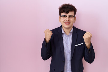 Poster - Young non binary man with beard wearing suit and tie celebrating surprised and amazed for success with arms raised and open eyes. winner concept.