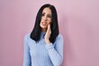© Krakenimages.com - Hispanic woman standing over pink background touching mouth with hand with painful expression because of toothache or dental illness on teeth. dentist