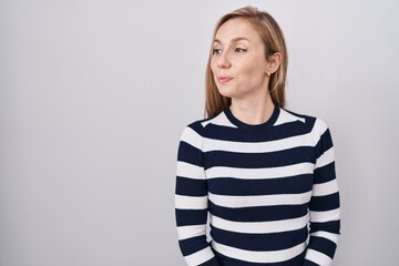 Canvas Print - Young caucasian woman wearing casual navy sweater smiling looking to the side and staring away thinking.