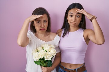 Poster - Hispanic mother and daughter holding bouquet of white flowers worried and stressed about a problem with hand on forehead, nervous and anxious for crisis