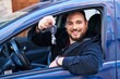© Krakenimages.com - Young hispanic man holding key sitting on car at street