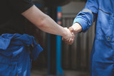 Fototapeta  - Two professional auto mechanics shaking hands, all kinds of car specialists, expert auto repair and standard auto repair center.