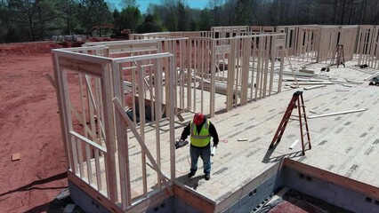 Wall Mural - Contractor is hammering nail as he builds new wooden house by framing