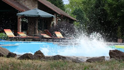 Wall Mural - A young group of people jumping into the swimming pool. Having fun and refreshing on a hot summer day.