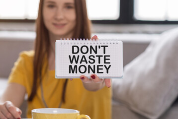 Smiling woman holding brochure with Don't Waste Money, text on grey background.