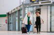 © ADDICTIVE STOCK - Happy mature women walking in airport corridor with suitcases