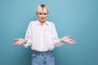 © Ivan Traimak - portrait of a confused young pretty blond business woman in a white blouse and jeans on a background with copy space. business concept