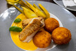 Fillet from fish cod, polenta croquet in carrot and orange purre, fennel on striped plate.