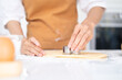 © Fahng - Cropped image of hands cutting cookies of dough while baking in kitchen .Making for homemade biscuits. On the table is dough and a set of cookie molds with other kitchen equipment.
