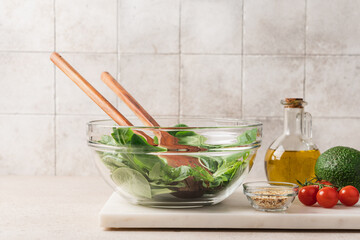 Wall Mural - Fresh green lettuce leaves mix in glass bowl. Cooking healthy and delicious food. Diet food concept