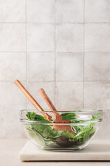 Wall Mural - Fresh green lettuce leaves mix in glass bowl. Cooking healthy and delicious food. Diet food concept