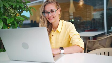 Worldwide work Female developer working on laptop sitting terrace cafe. Woman freelancer coding at outdoor restaurant use laptop close up portrait shot. Caucasian girl working remotely. Remote job
