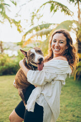 woman playing with her dog on the grass