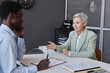 © Seventyfour - Side view portrait of elegant senior businesswoman talking to HR recruiter at job interview