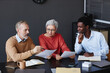 © Seventyfour - Diverse group of business people with senior workers collaborating on project together in office