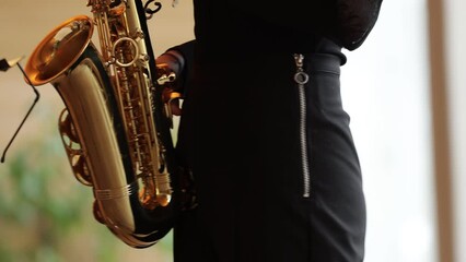 Poster - a girl in a black suit plays the saxophone