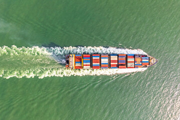 Wall Mural - Aerial top view of cargo maritime ship with contrail in the ocean ship carrying container and running.
