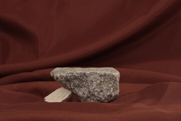 Stone platform podium on brown silk fabric background. Minimal empty display product presentation scene.