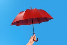 Hand Holding Red Umbrella On Blue Background, Generative AI
