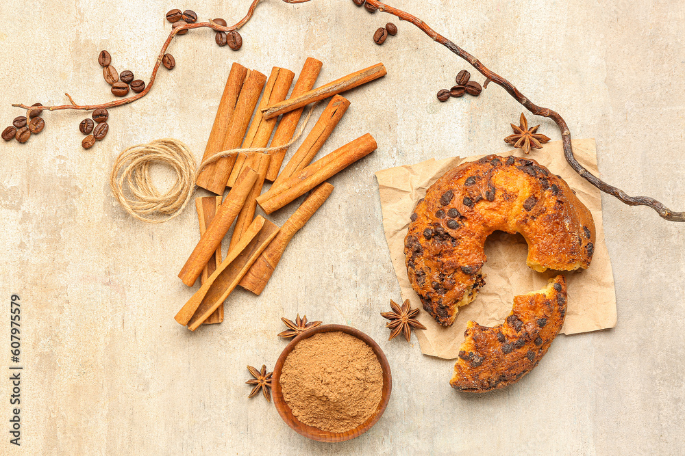 Composition with cinnamon sticks, powder, tree branch and tasty cake on grunge background