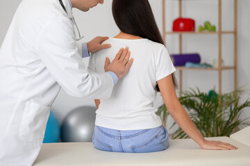 Poster - Male doctor checking posture of young woman in clinic