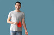 Young blood donor with applied medical patch and paper drop on blue background