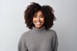 © Hanne Bauer - Portrait of a smiling young african american woman looking at camera over gray background