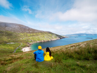 Father and daughter on a trip to nature with stunning view. Nature scene in the background with mountains, beach, ocean and cloudy sky. Separated after divorce family concept. Parent day theme.