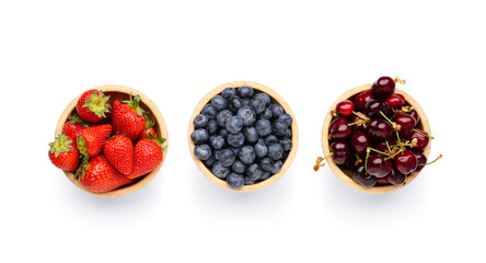 Wall Mural - Bowls with ripe cherry, strawberry and blueberry on white background