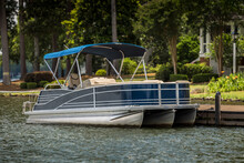 Pontoon Boat At Private Dock On Freshwater Lake.