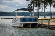Pontoon Boat At Private Dock On Freshwater Lake.