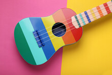 Bright Ukulele On Color Background, Top View. String Musical Instrument