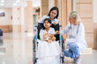 © ronnachaipark - Female pediatrician doctor and child patient on wheelchair with her mother in the health medical center