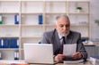 © Elnur - Old male employee working in the office