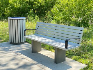 Banc de parc dans une air d'attente à la gare proche d'un corbeille à déchets. Mobilier publique pour se reposer en attendant les transports en commun. Propreté des lieux.