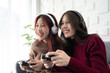 © Jestercine - Two asian woman playing game in living room. They playing with happy emotion together.