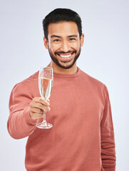 Poster - Man with smile in portrait, champagne and cheers with celebration and happiness isolated on studio background. Toast with alcohol drink in glass, happy male model and party, celebrate with drinking