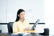 © ND STOCK - Confident businesswoman holding tablet and smiling at the camera, in meeting room on white background.