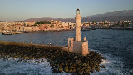 Poster - Aerial circling camera view of a Venetian era lighthouse in golden sunset light (Chania)