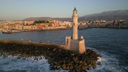 Wall Mural - Aerial circling camera view of a Venetian era lighthouse in golden sunset light (Chania)