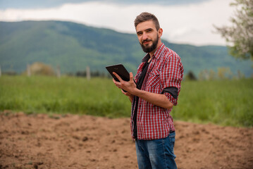 Sticker - Male farmer plantation checking quality by tablet agriculture modern technology concept smart farming agronomist checking soil quality on the field.