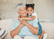© K.A./peopleimages.com - Family, grandmother and grandchild hug with smile in portrait, happiness and bonding at home. Love, care and trust with elderly woman and young child in living room, embrace and happy at house