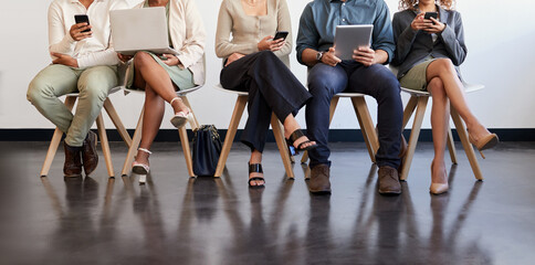 Technology, legs and people waiting for an interview in line at a human resources office as candidates for a vacancy. We are hiring, recruitment and opportunity with man and woman employees online