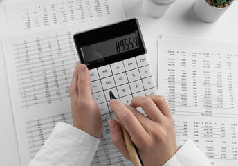 Poster - Accountant using calculator on desk office on white background with financial statement. Top view