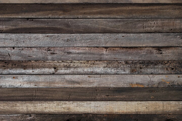 Image of vintage hardwood board with rough surface. Close up pattern and textured from old plank wooden wall with soft light. Natural brown color background.