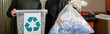 © LIGHTFIELD STUDIOS - Cropped view of volunteers holding trash bin with recycle sign and bag in blurred waste disposal station at background, garbage sorting and recycling concept, banner