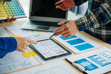 UX developer and ui designer brainstorming about mobile app interface wireframe design with customer breif and color code at modern office..