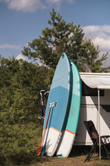 Wall Mural - The sup board stands near the motorhome. a vacation trip in a motorhome, a vacation in a van