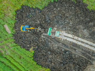 Wall Mural - Aerial view of excavator equipment at the construction site. The excavator digs earthwork at the construction site.