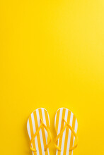 Delight In The Beauty Of Summer With This Eye-catching Top Vertical View Flat Lay. Discover A Pair Of Flip-flop Shoes On A Bright Yellow Background, With A Blank Space For Your Text Or Advertisement